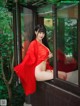 A woman in a red kimono sitting on a window sill.