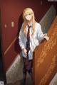 A woman in a white shirt and tie standing on a staircase.